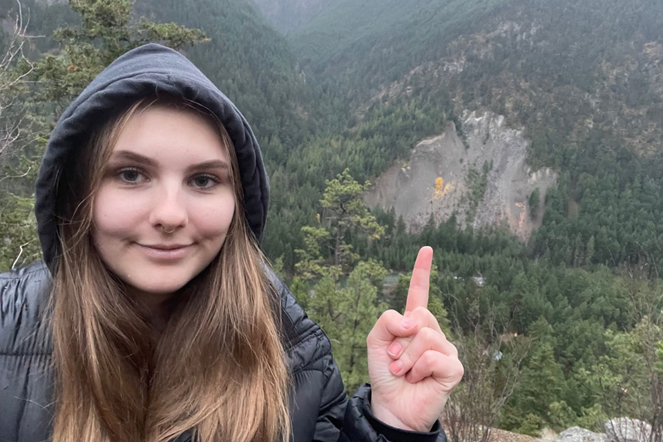 Katrijn pointing to a landslide in the background