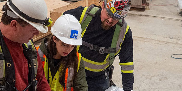 Student at a co-op job looking at floor plans with coworkers