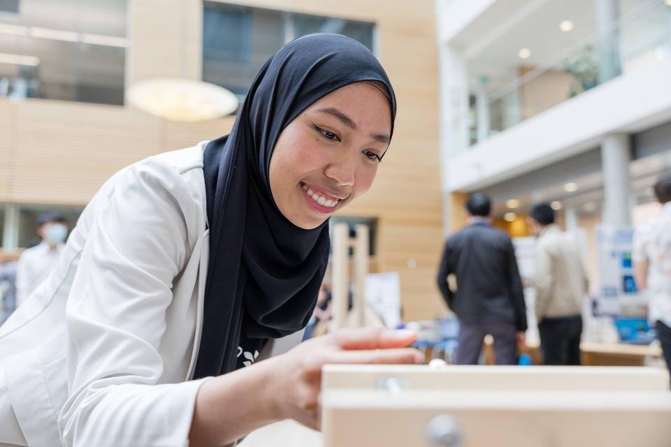 An engineering student at the Design and Innovation day exhibit
