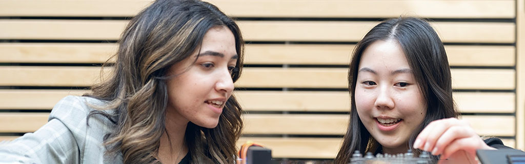 Two girls talking about their project at Design and Innovation Day