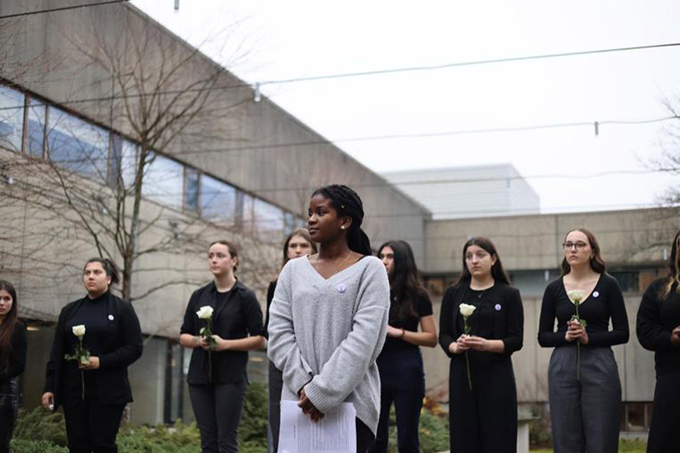 Engineering students dressed in black hold a white rose for each victim.