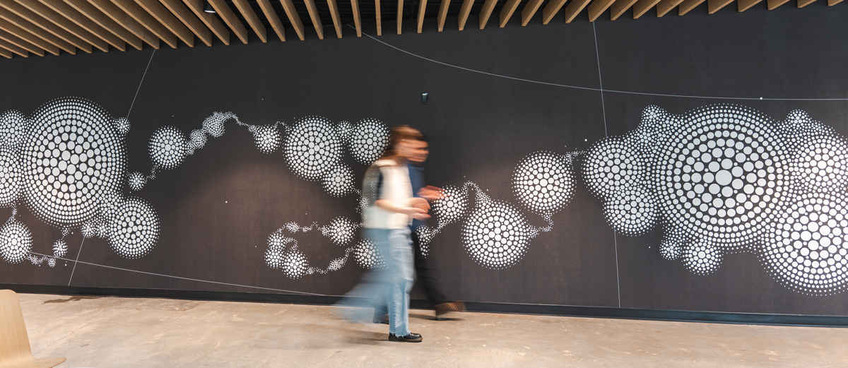 Students walk in front of a large mural