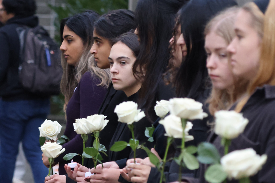 Students hold white roses