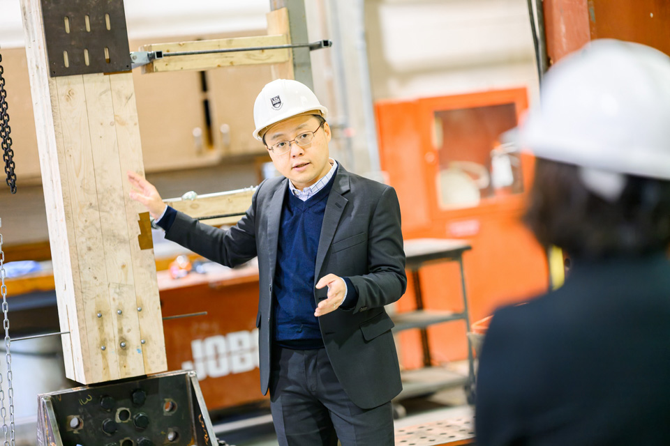 Tony Yang points to a beam in his lab