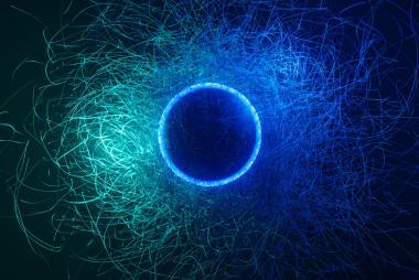 Abstract image of blue circle with green and blue lines swirling out of it