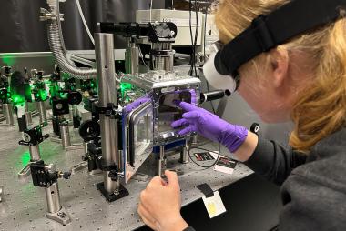 Christina Hofer places a sample into a device in a lab