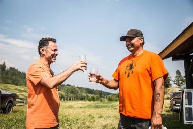 Prof Madjid Mohseni toasting a glass of water with a community partner
