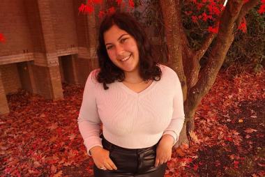 Eve Sankar in front of a tree with red leaves