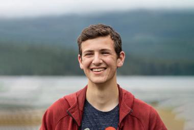 Elio Di Nino outside with mountains and water in the background