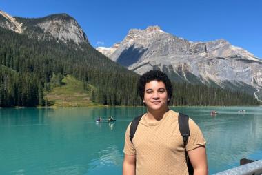 Yousif El-Wishahy in a picturesque outdoor setting with water and mountains in the background