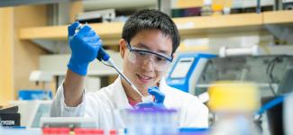 Student in a lab using a micropipette.