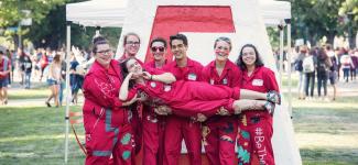 Group of students carrying the EUS president in front of the cairn.