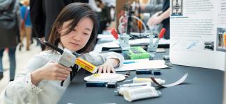 A female student working on her project booth at Design and Innovation Day