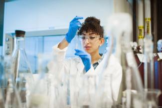 Student in a lab holding a mini Erlenmeyer flask.