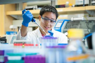 Student in a lab using a micropipette.