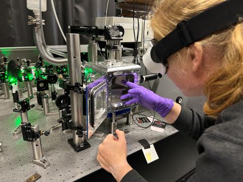 Christina Hofer places a sample into a device in a lab