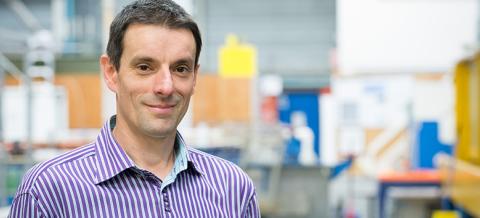 A head shot of Dr. Bernard Laval. The background is an out-of-focus lab.