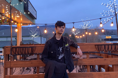 Preeyansh taking a photo at dusk, in front of lit up Christmas lights