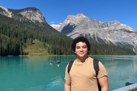 Yousif El-Wishahy in a picturesque outdoor setting with water and mountains in the background