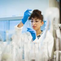 Student in a lab holding a mini Erlenmeyer flask.